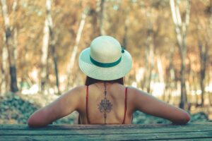 A woman with a back tattoo contemplating how to get that tattoo removed in nearby Foster City, California.